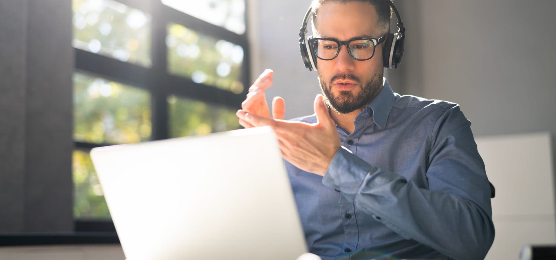 Profesional con audífonos capacitándose frente a una laptop en un ambiente de aprendizaje digital